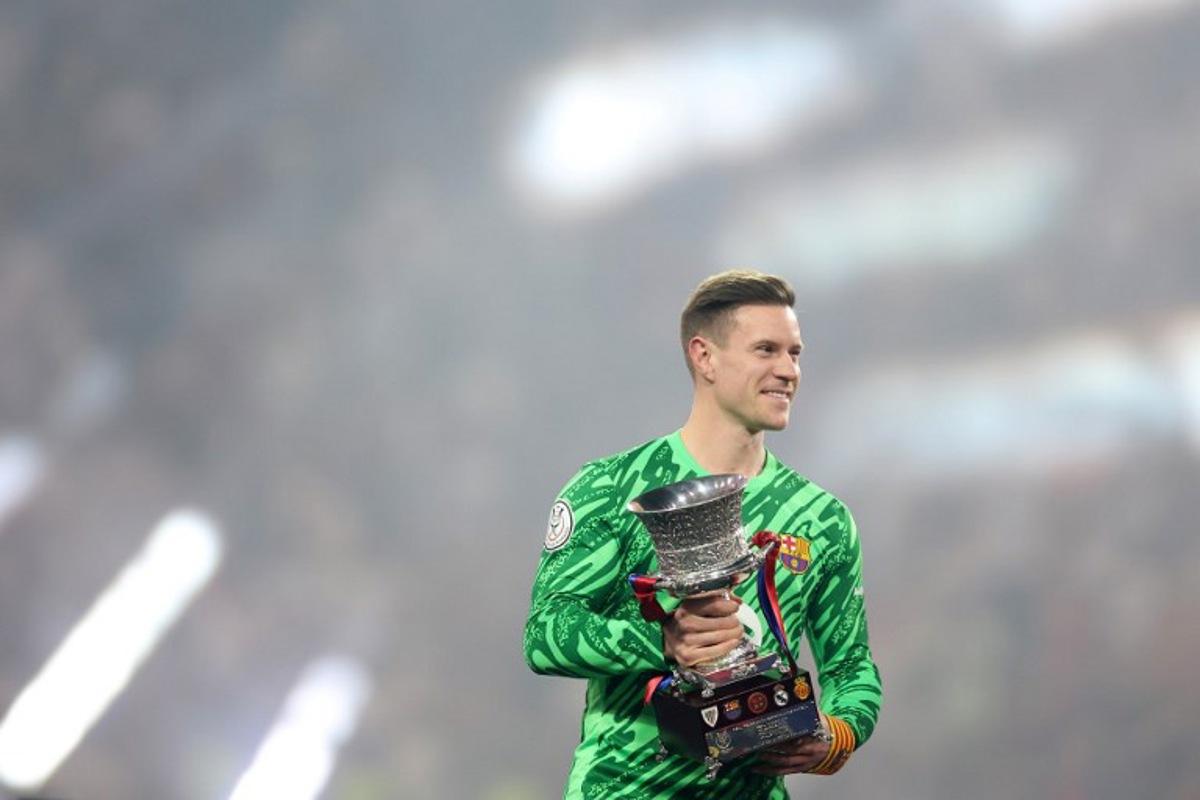 Barcelona's German goalkeeper #1 Marc-Andre Ter Stegen lifts the trophy after winning the Spanish Super Cup final football match between Real Madrid and Barcelona at the King Abdullah Sport City in Jeddah on January 12, 2025. Haitham AL-SHUKAIRI / AFP