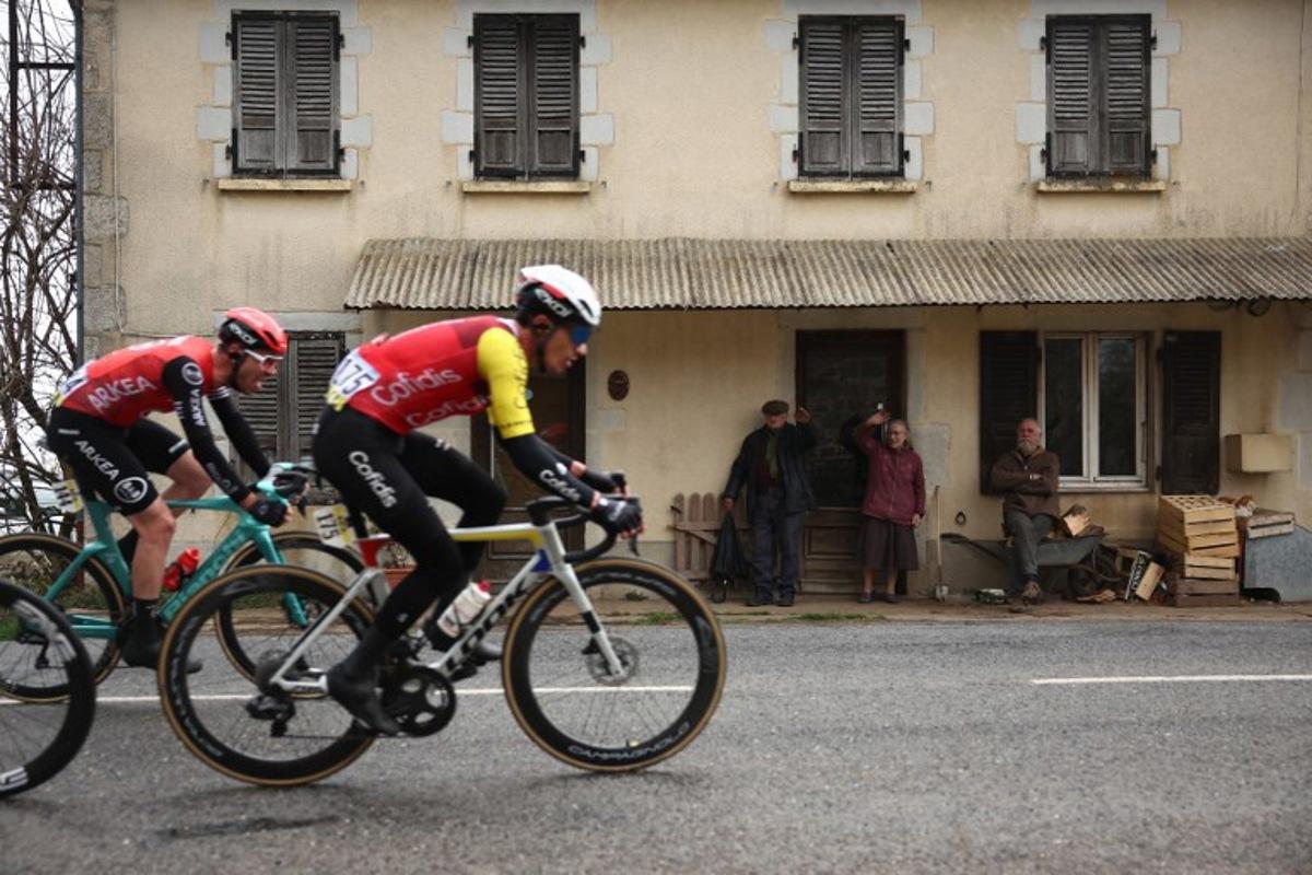 Arkea-B&B Hotels' French rider Thibault Guernalec (L) and Cofidis' Belgian rider Sylvain Moniquet cycle in a breakaway past local residents during the 4th stage of the Paris-Nice cycling race, 163,4 km between Vichy and La Loge des Gardes, on March 12, 2025. Anne-Christine POUJOULAT / AFP