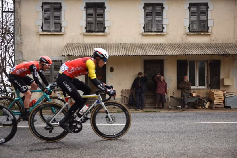 Arkea-B&B Hotels' French rider Thibault Guernalec (L) and Cofidis' Belgian rider Sylvain Moniquet cycle in a breakaway past local residents during the 4th stage of the Paris-Nice cycling race, 163,4 km between Vichy and La Loge des Gardes, on March 12, 2025. Anne-Christine POUJOULAT / AFP