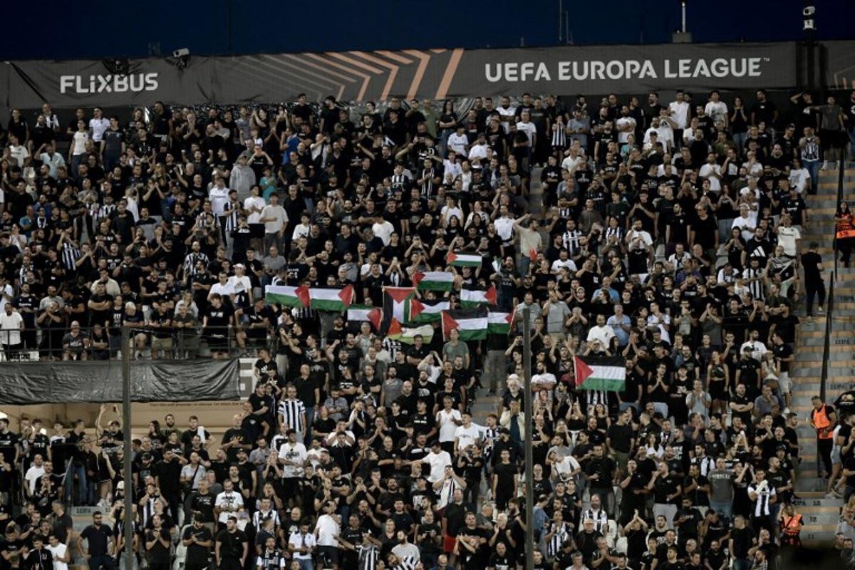 PAOK fans hold Palestinian flags during the UEFA Europa League football match day 1, between PAOK Salonika and Maccabi Tel-Aviv at the Toumba Stadium, in Thessaloniki on September 24, 2025. SAKIS MITROLIDIS / AFP