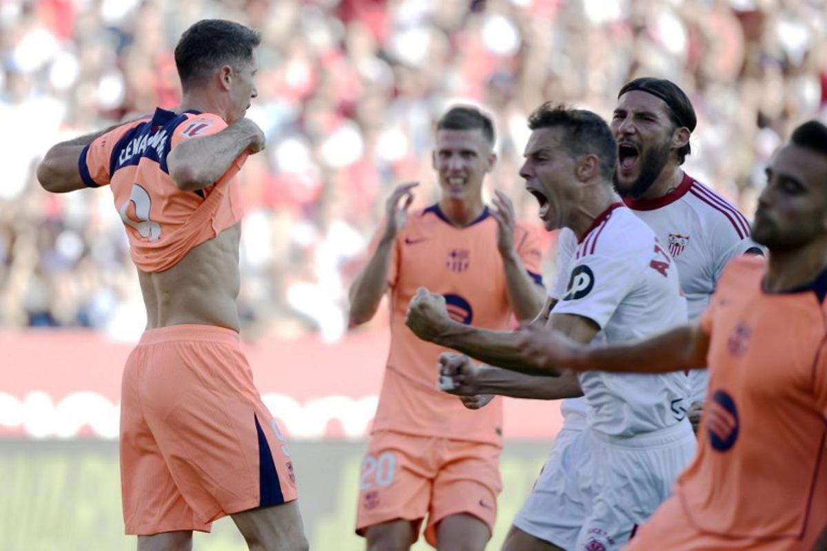 Barcelona's Polish forward #09 Robert Lewandowski (L) reacts to missing a penalty kick during the Spanish league football match between Sevilla FC and FC Barcelona at Ramon Sanchez Pizjuan Stadium in Seville on October 5, 2025. CRISTINA QUICLER / AFP