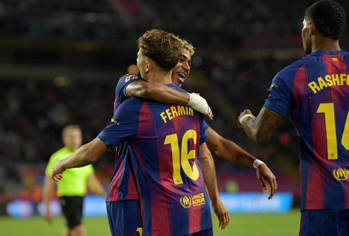 Barcelona's Spanish forward #10 Lamine Yamal celebrates scoring his team's first goal with Barcelona's Spanish midfielder #16 Fermin Lopez and Barcelona's English forward #14 Marcus Rashford during the Spanish league football match between FC Barcelona and Elche CF at Estadi Olimpic Lluis Companys in Barcelona on November 2, 2025. MANAURE QUINTERO / AFP
