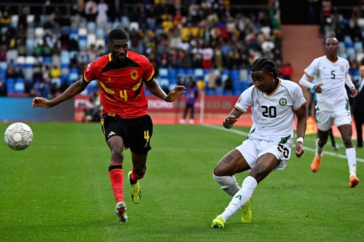 Zimbabwe's forward #20 Tawanda Chirewa crosses the ball past Angola's defender #04 Clinton Mata during the Africa Cup of Nations (CAN) Group B football match between Angola and Zimbabwe at Marrakesh Stadium in Marrakesh on December 26, 2025. Khaled DESOUKI / AFP