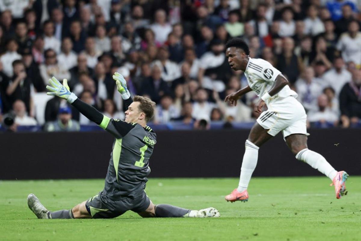 Real Madrid's Brazilian forward #07 Vinicius Junior (R) tries to score past Bayern Munich's German goalkeeper #01 Manuel Neuer during the UEFA Champions League quarter final first leg football match between Real Madrid CF and FC Bayern Munich at Santiago Bernabeu Stadium in Madrid on April 7, 2026. Thomas COEX / AFP