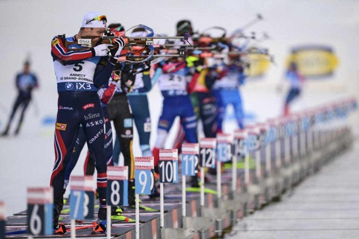 Norway's Vetle Sjaastad Christiansen (L) fires his rifle during the men's 15km mass start event of the IBU Biathlon World Cup, in Le Grand Bornand, near Annecy, southeastern France, on December 21, 2025. Olivier CHASSIGNOLE / AFP