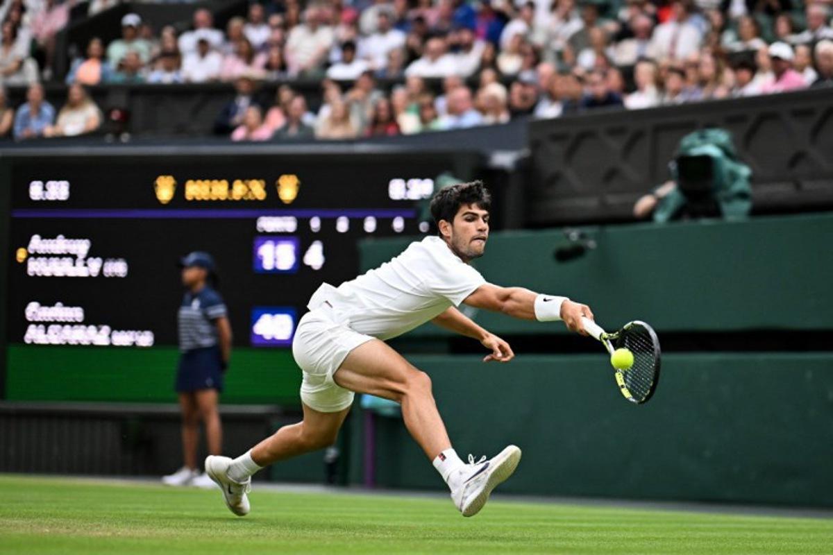 Spain's Carlos Alcaraz plays a backhand return to Russia's Andrey Rublev during their men's singles fourth round tennis match on the seventh day of the 2025 Wimbledon Championships at The All England Lawn Tennis and Croquet Club in Wimbledon, southwest London, on July 6, 2025. Kirill KUDRYAVTSEV / AFP