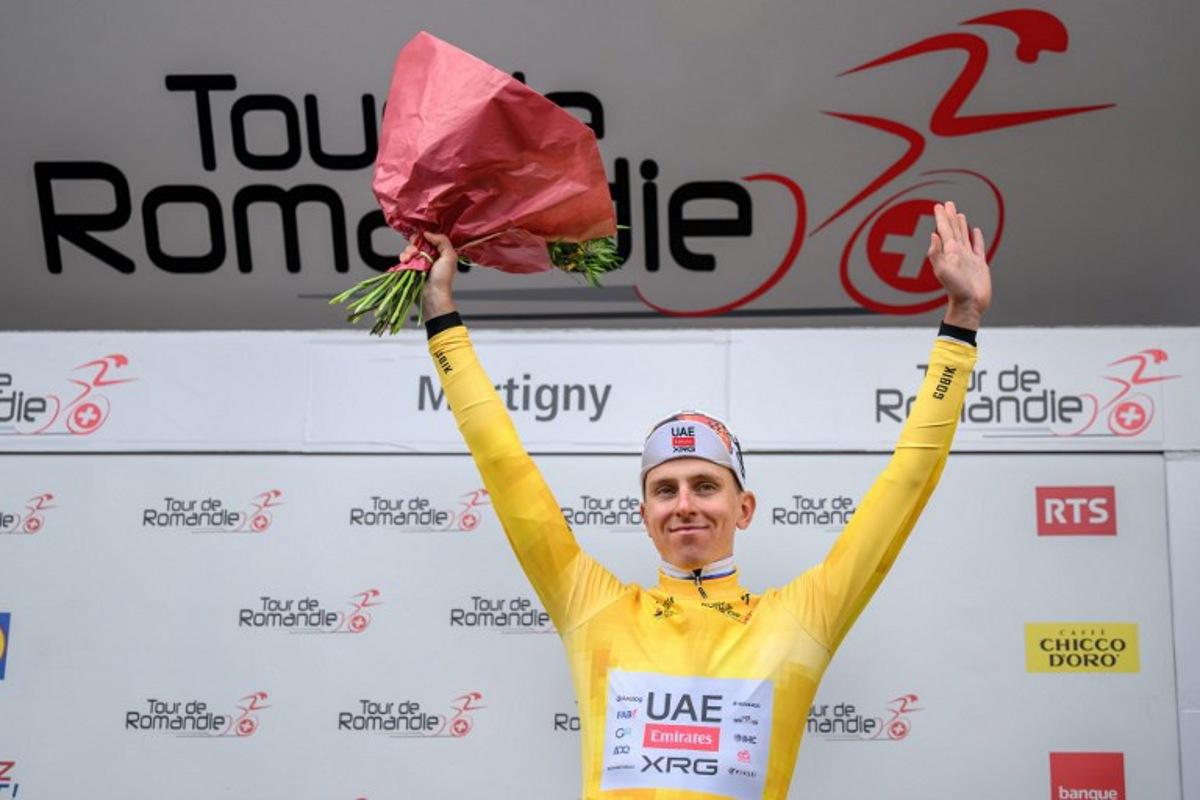 UAE Team Emirates-XRG's Slovenian rider Tadej Pogacar wearing the overall leader's yellow jersey celebrates on the podium of the first stage of the Tour of Romandie UCI cycling World tour, a 171.2 km loop from Martigny-Ville to Martigny-Ville, in Martigny, on April 29, 2026. Fabrice COFFRINI / AFP