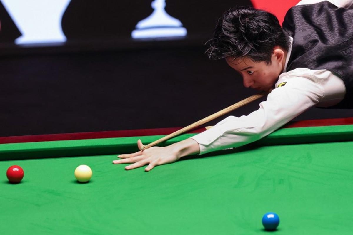 China's Wu Yize plays a shot against England's Shaun Murphy during the World Snooker Championship final round at The Crucible in Sheffield, northern England on May 4, 2026. Darren Staples / AFP