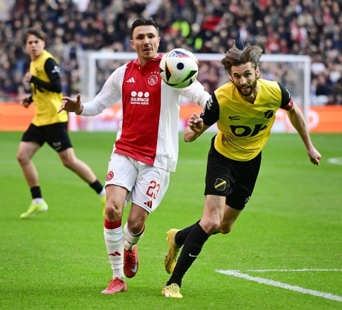 Ajax's Dutch forward #23 Steven Berghuis (L) fights for the ball with Breda's Belgian defender #05 Jan van den Bergh during the Dutch Eredivisie football match between Ajax Amsterdam and NAC Breda at the Johan Cruijff ArenA in Amsterdam, on April 6, 2025. Olaf KRAAK / ANP / AFP