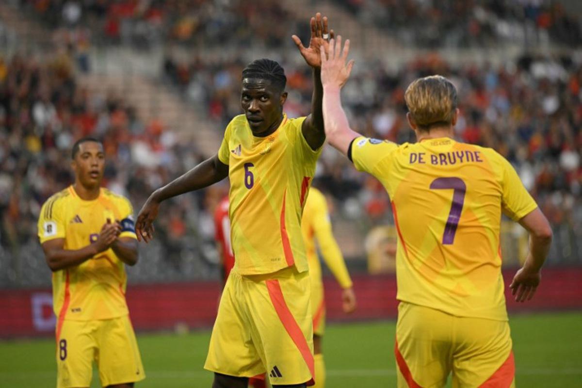 Belgium's midfielder #06 Amadou Onana (C) and Belgium's midfielder #07 Kevin De Bruyne (R) high five each other during the FIFA World Cup 2026 Group J European qualification football match between Belgium and Wales at the King Baudouin Stadium in Brussels, on June 9, 2025. NICOLAS TUCAT / AFP