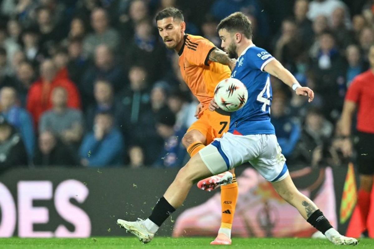 Roma's Italian midfielder #07 Lorenzo Pellegrini (L) plays the ball past Rangers' Belgian midfielder #43 Nicolas Raskin (R) during the UEFA Europa League league-stage football match between Rangers and Roma at Ibrox Stadium in Glasgow on November 6, 2025. ANDY BUCHANAN / AFP