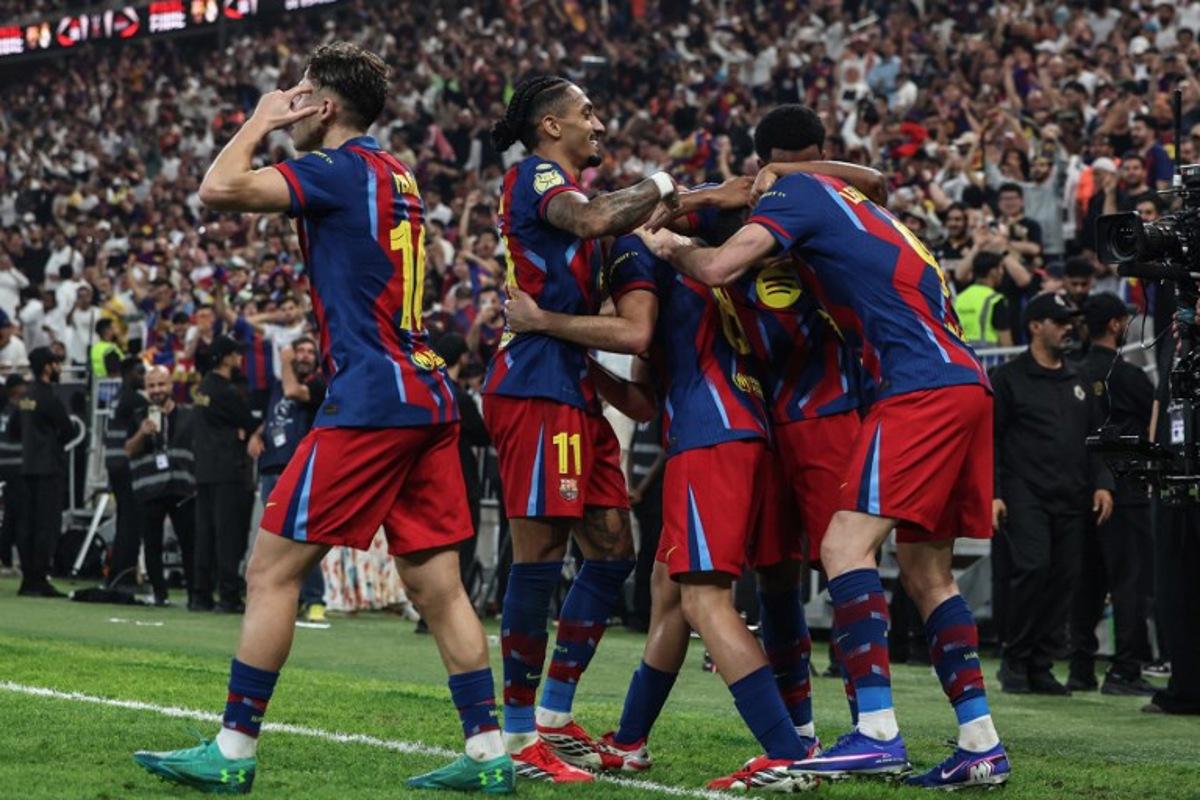 Barcelona's Polish forward #09 Robert Lewandowski celebrates with teammates after scoring his team's second goal during the Spanish Super Cup final football match between FC Barcelona and Real Madrid at the King Abdullah Stadium in Jeddah on January 11, 2026. Fadel SENNA / AFP