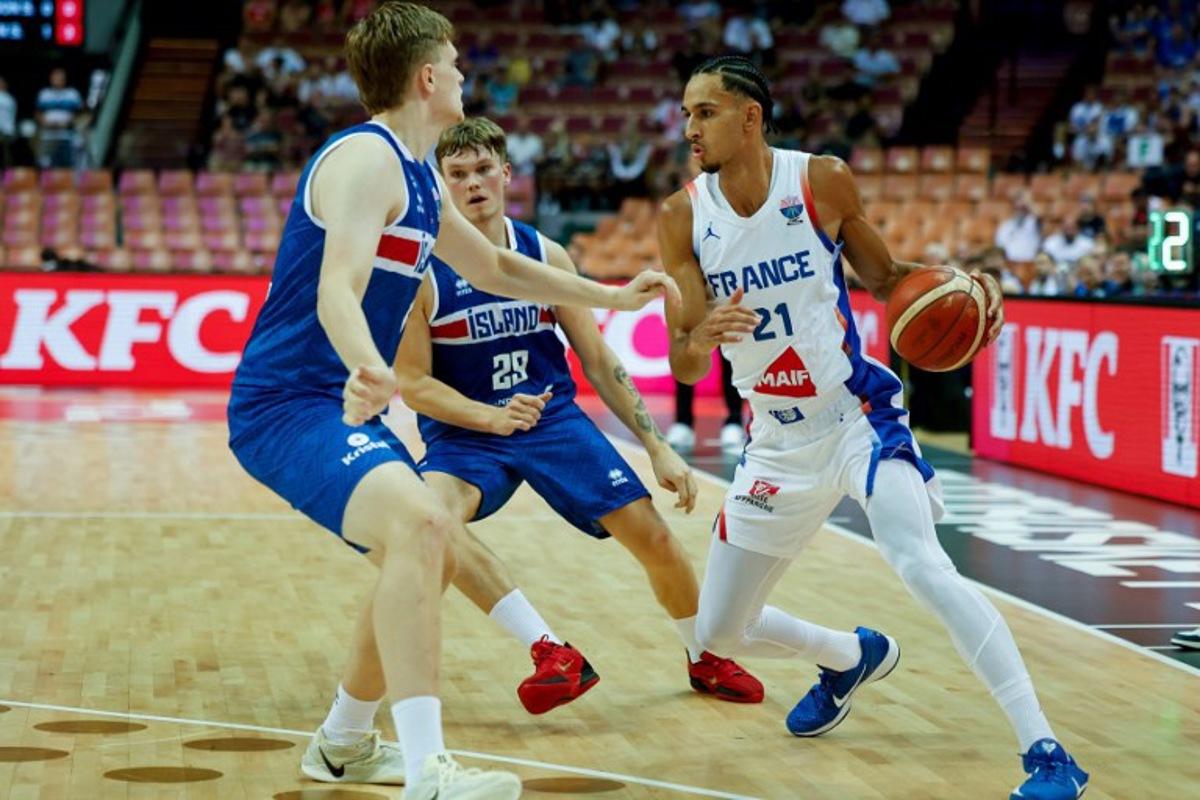 France's small forward #21 Zaccharie Risacher (R) and Iceland's forward #29 Orri Gunnarsson (C) vie during the FIBA EuroBasket 2025 Group D basketball match between France and Iceland at the Spodek Arena in Katowice, Poland on September 4, 2025. Wojtek RADWANSKI / AFP