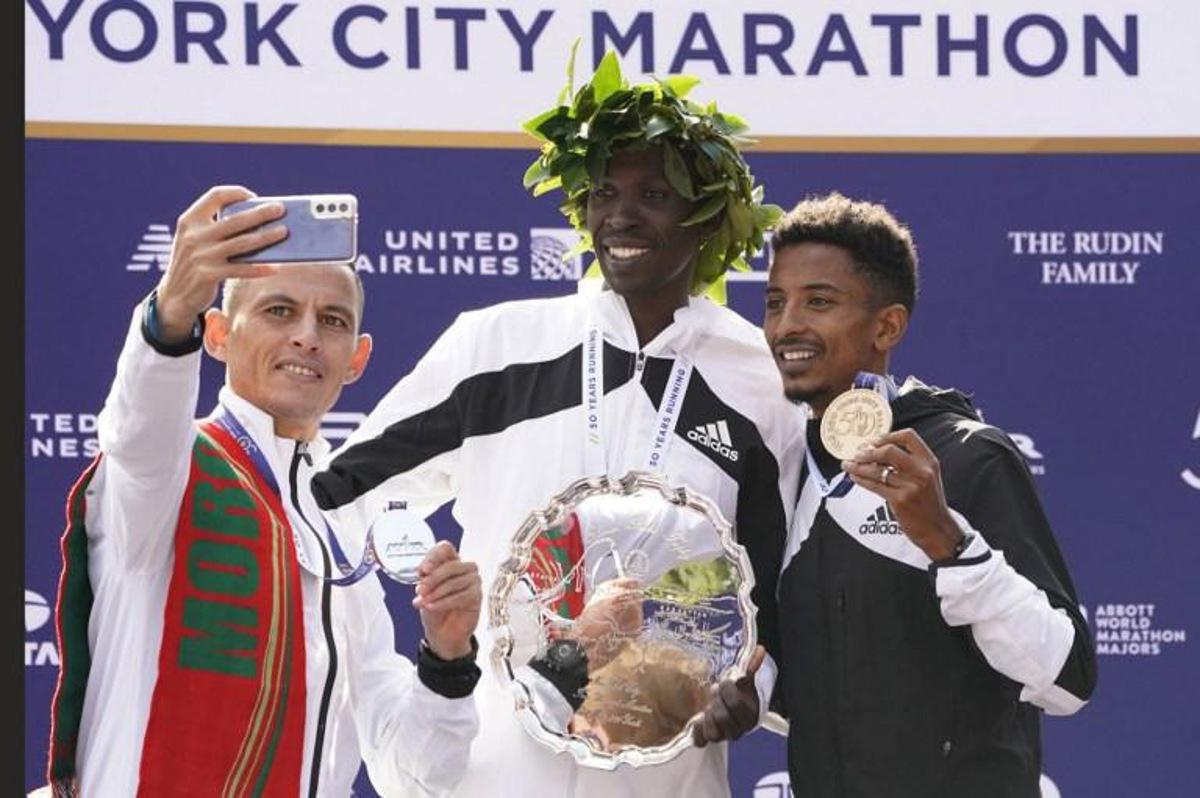 Men's division winners Albert Korir Kenya (C), 2nd place winner Mohamed Reda El Aaraby of Morocco (L), and 3rd place winner Eyob Faniel of Italy pose on the podium after the 2021 TCS New York City Marathon in New York on November 7, 2021. After a forced break in 2020, the New York City Marathon is back on for its 50th edition, and with it the countless opportunities to run it for charity, an industry that has become a staple, and hopes to take off again after the pandemic. TIMOTHY A. CLARY / AFP