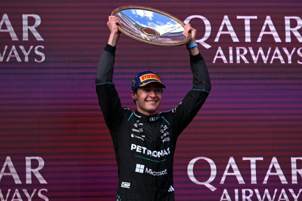 Mercedes' British driver George Russell celebrates on the podium after winning the Formula One Australian Grand Prix at the Albert Park Circuit in Melbourne on March 8, 2026. WILLIAM WEST / AFP