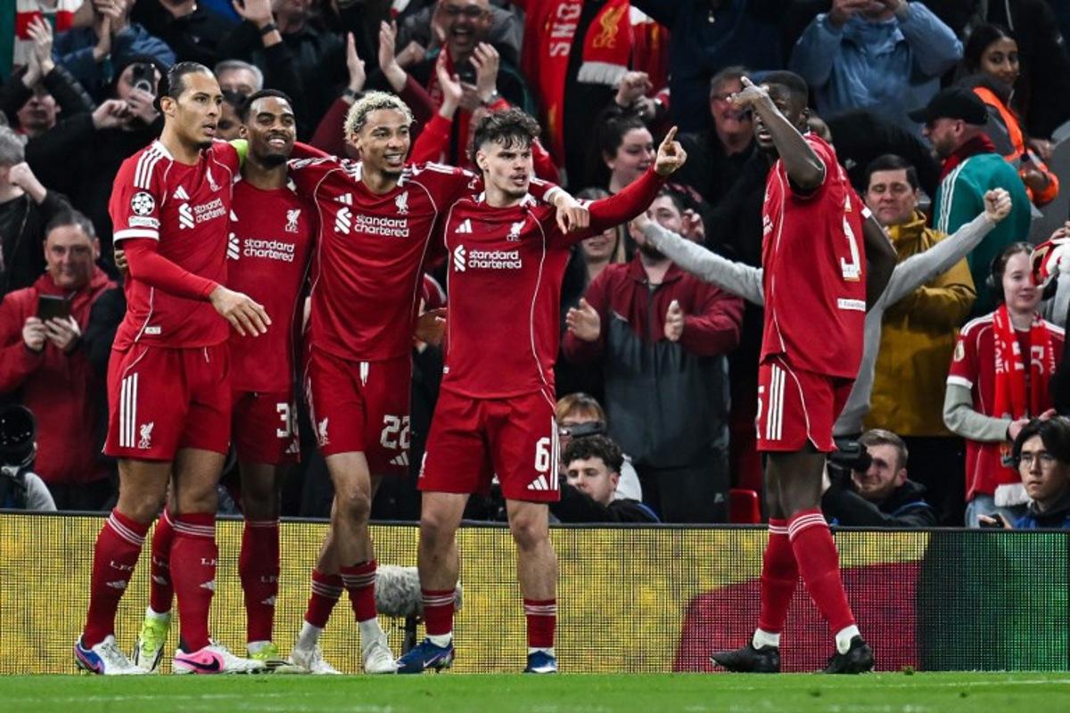 Liverpool's Dutch midfielder #38 Ryan Gravenberch (2L) celebrates with teammates after scoring his team's third goal during the UEFA Champions League, round of 16 second leg football match between Liverpool and Galatasaray at Anfield in Liverpool, north-west England on March 18, 2026. Paul ELLIS / AFP