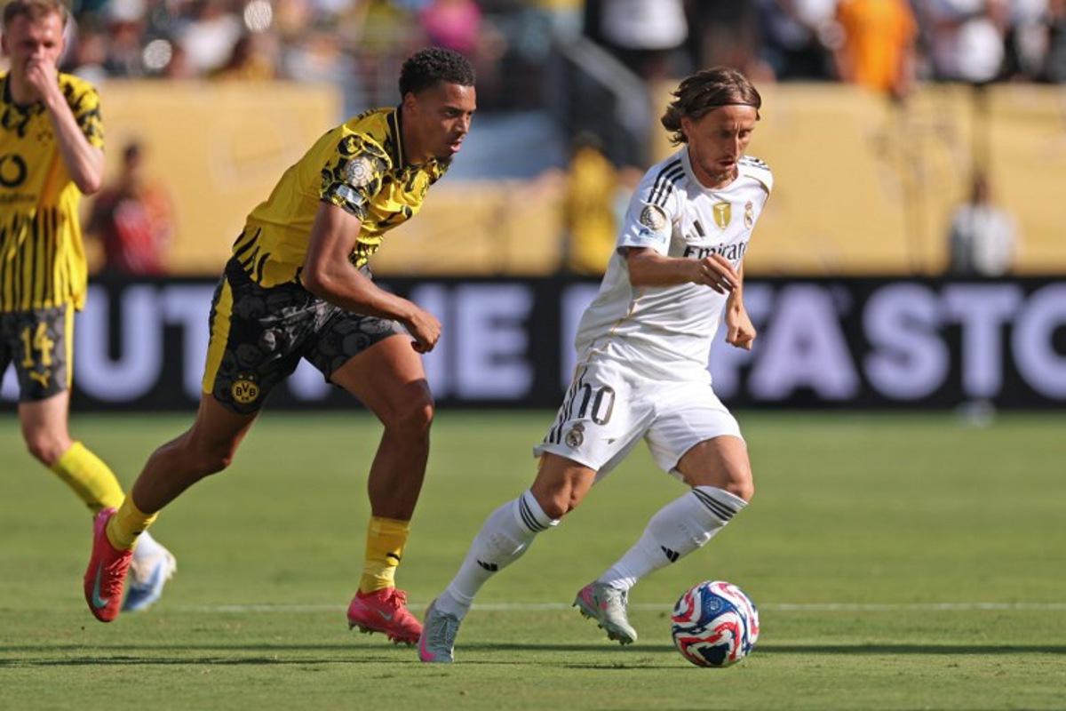 Guest, Borussia Dortmund's German midfielder #08 Felix Nmecha (L) fights for the ball with Real Madrid's Croatian midfielder #10 Luka Modric during the FIFA Club World Cup 2025 quarterfinal football match between Spain's Real Madrid and Germany's Borussia Dortmund at the MetLife stadium in East Rutherford, New Jersey on July 5, 2025. CHARLY TRIBALLEAU / AFP