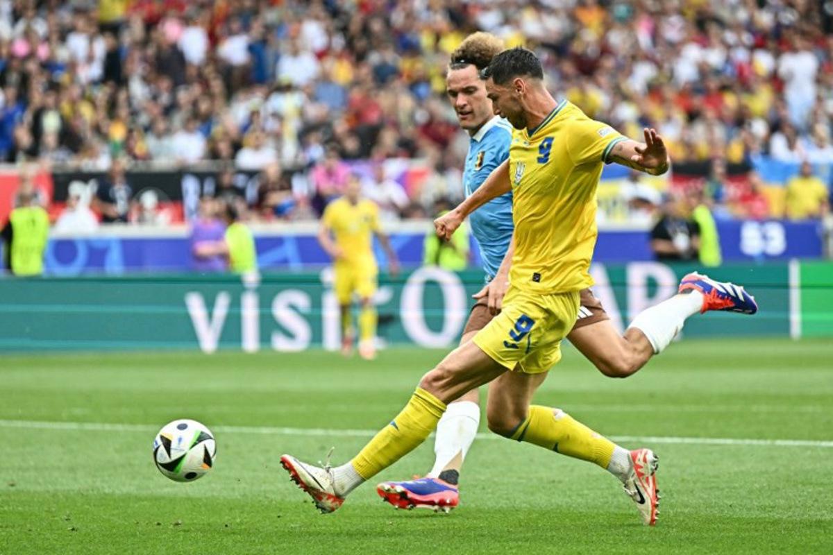 Ukraine's forward #09 Roman Yaremchuk runs with the ball past Belgium's defender #04 Wout Faes during the UEFA Euro 2024 Group E football match between Ukraine and Belgium at the Stuttgart Arena in Stuttgart on June 26, 2024. Fabrice COFFRINI / AFP