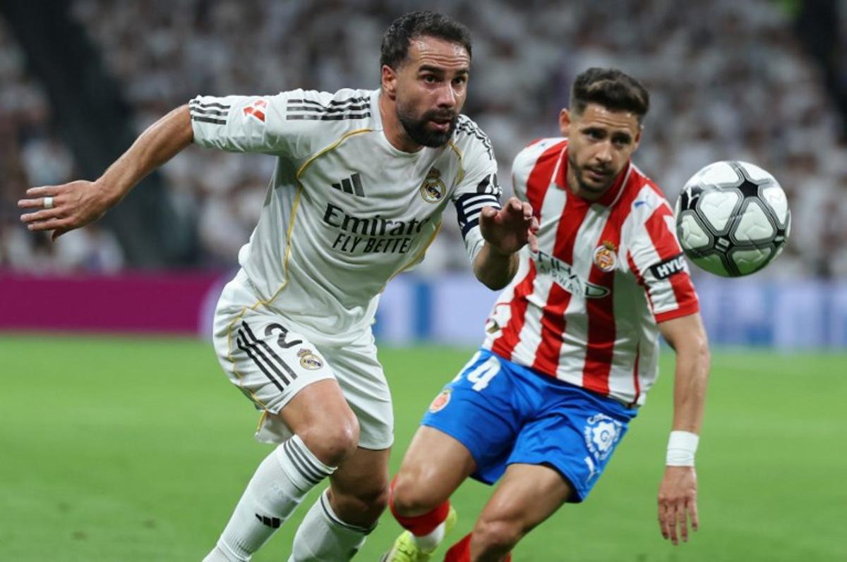 Real Madrid's Spanish defender #02 Dani Carvajal (L) vies for the ball with Girona's Spanish defender #24 Alexandre Moreno during the Spanish league football match between Real Madrid CF and Girona FC at the Santiago Bernabeu stadium in Madrid on April 10, 2026. Thomas COEX / AFP