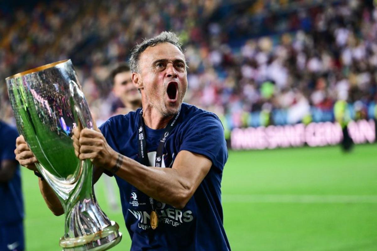 Paris Saint-Germain's Spanish headcoach Luis Enrique celebrates with the trophy after winning the 2025 UEFA Super Cup final football match between Paris Saint-Germain (FRA) and Tottenham Hotspur FC (ENG) at the Friuli stadium, in Udine, on August 13, 2025. Marco BERTORELLO / AFP