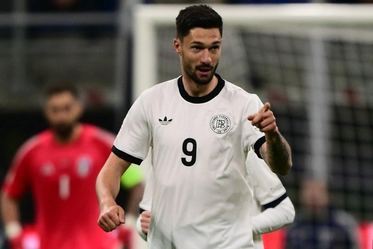 Germany's forward #09 Tim Kleindienst celebrates after scoring his team's first goal during the Nations League quarter final first leg football match between Italy and Germany at the San Siro Stadium in Milan, on March 20, 2025. Marco BERTORELLO / AFP
