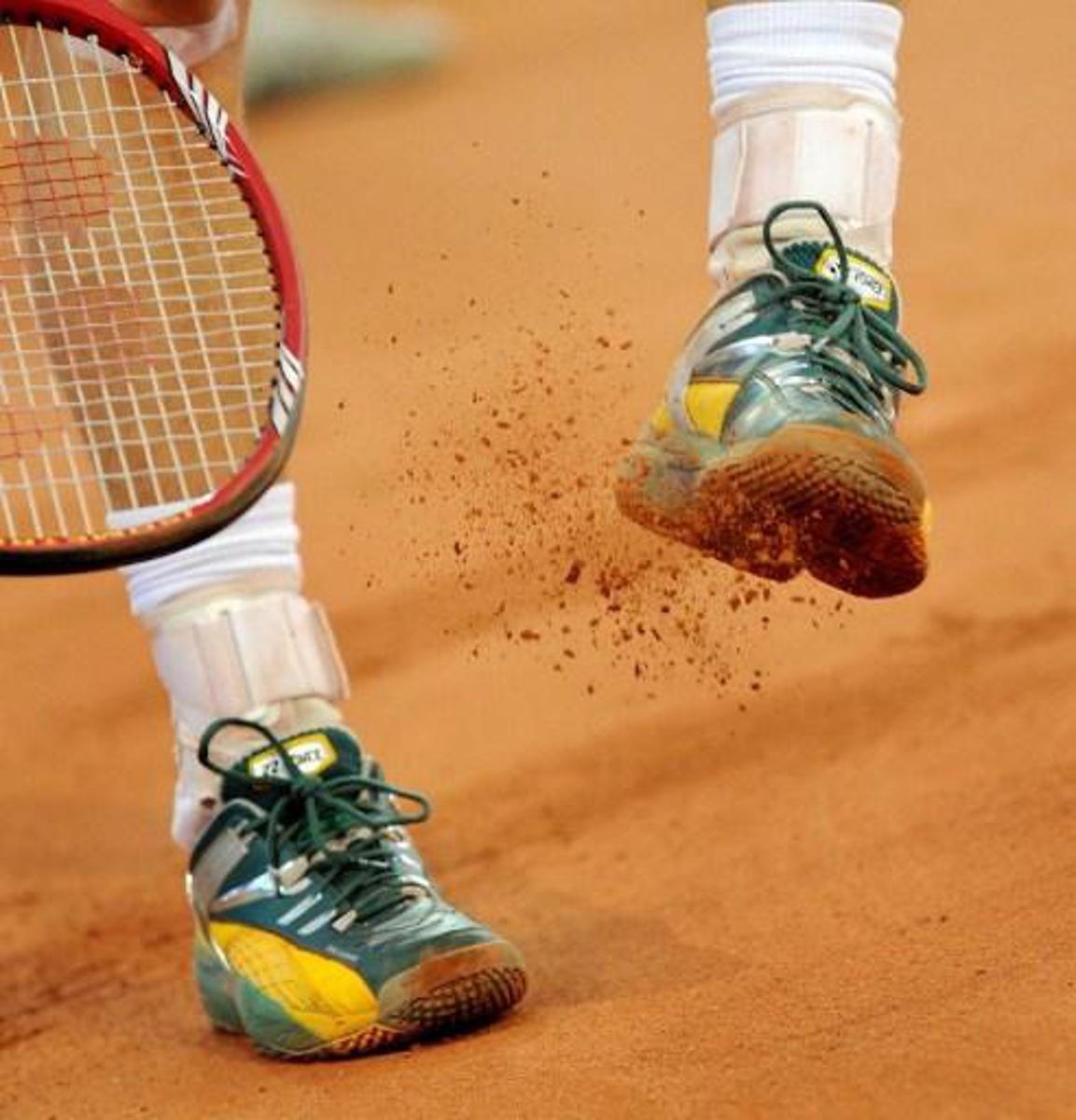 Australia's Lleyton Hewitt hits the clay from his shoe in his match against Yuichi Sugita of Japan during their Davis Cup tennis tie played in Brisbane on May 9, 2010. Hewitt won the dead rubber 7-5, 6-2 to give Australia an unbeatable 4-0 lead. RESTRICTED TO EDITORIAL USE NO ADVERTISING USE NO PROMOTIONAL USE NO MERCHANDISING USE AFP PHOTO/William WEST RESTRICTED TO EDITORIAL USE NO ADVERTISING USE NO PROMOTIONAL USE NO MERCHANDISING USE