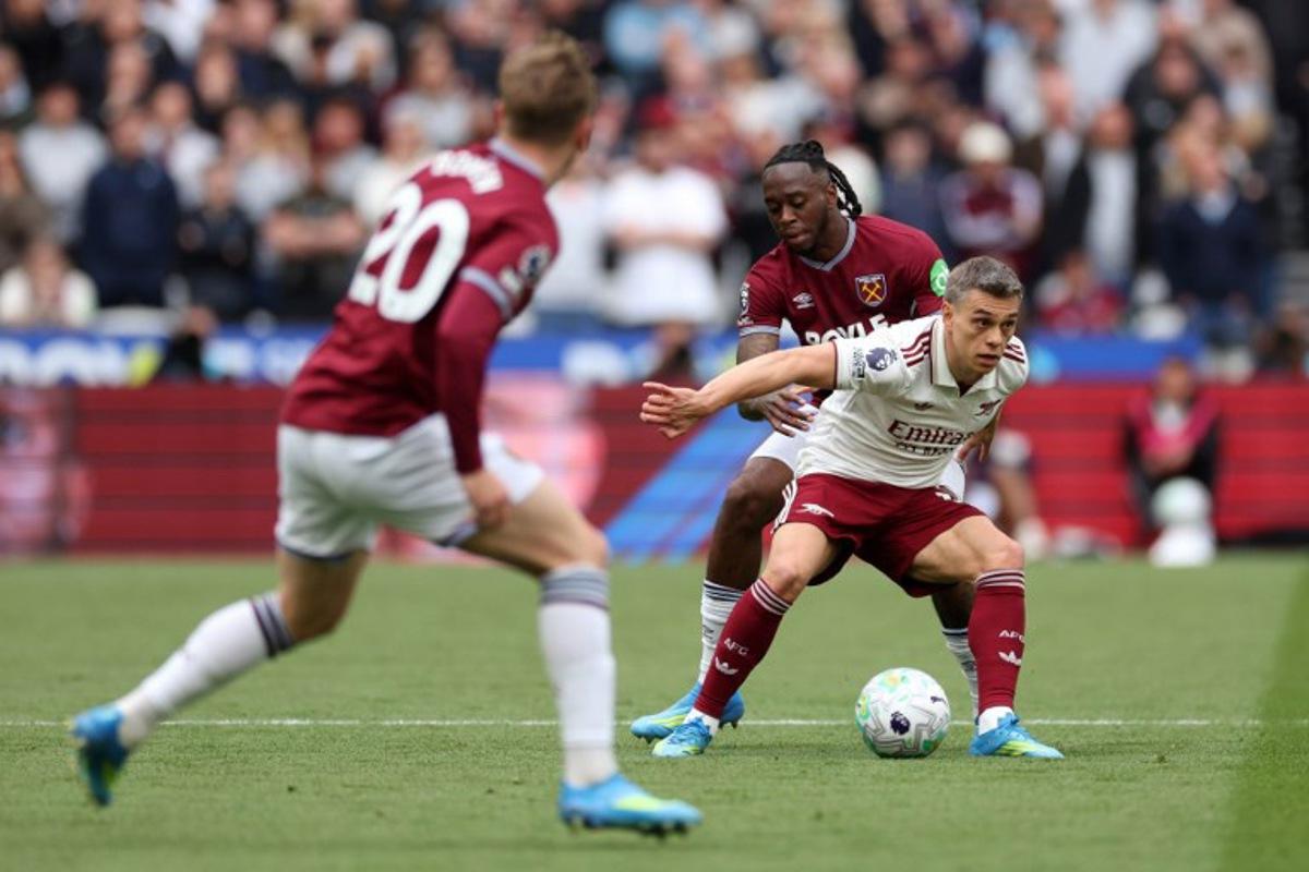 Arsenal's Belgian midfielder #19 Leandro Trossard is put under pressure by West Ham United's English defender #29 Aaron Wan-Bissaka during the English Premier League football match between West Ham United and Arsenal at the London Stadium, in east London on May 10, 2026. Adrian Dennis / AFP