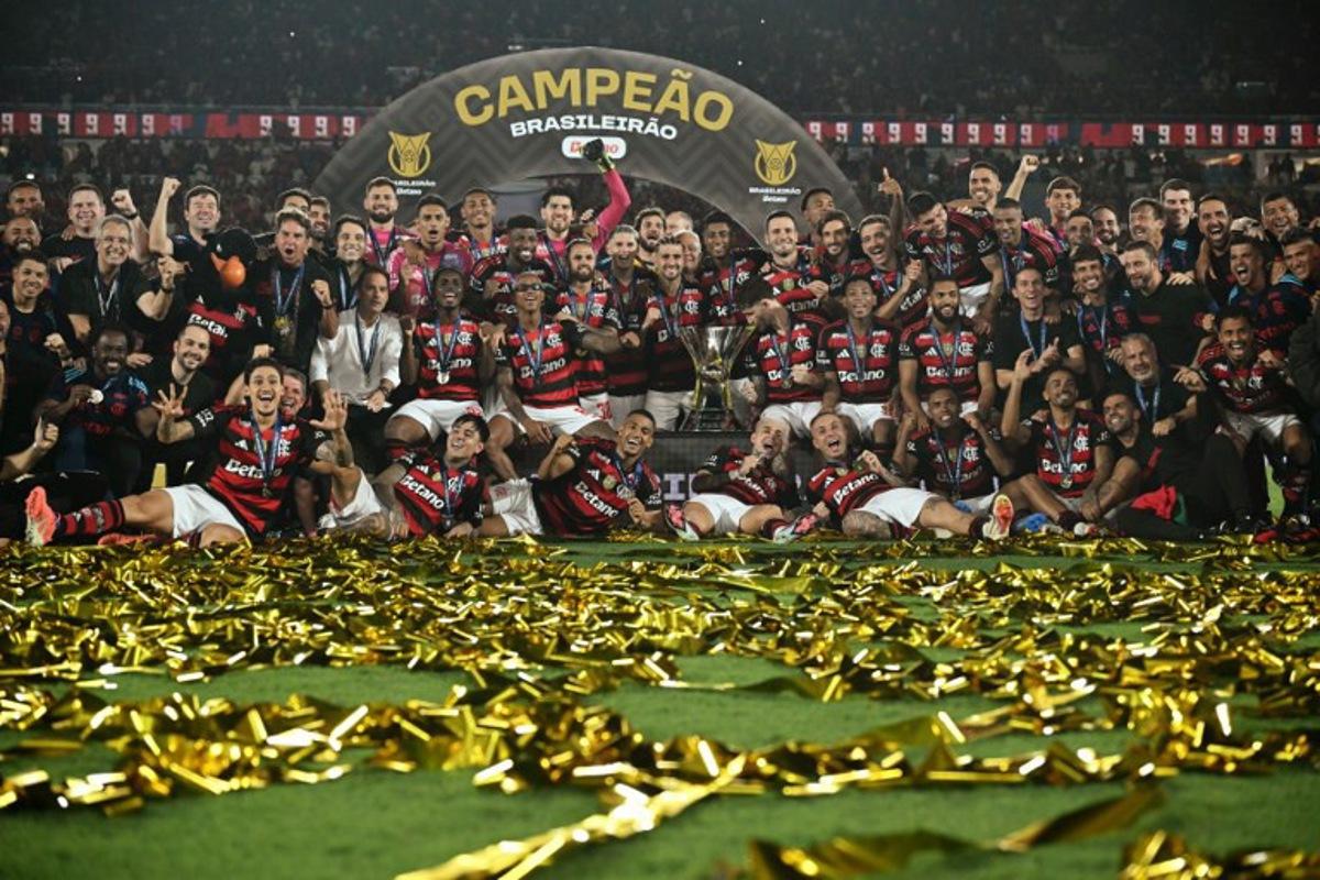 Flamengo's players celebrate with the Brasileirao trophy after winning the Brasileirao Serie A football match between Flamengo and Ceara at Maracana Stadium in Rio de Janeiro, Brazil, on December 3, 2025. Mauro PIMENTEL / AFP