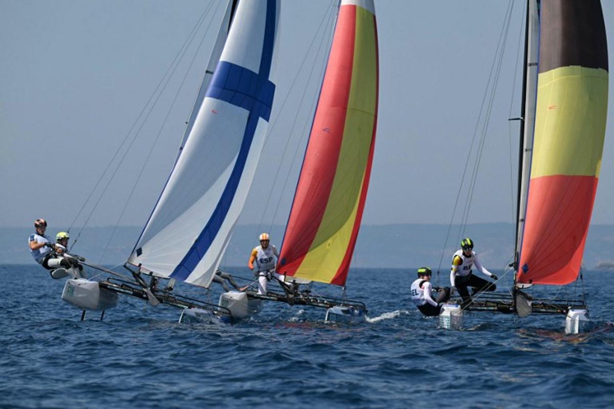 (LtoR) Finland's duo Sinem Kurtbay and Akseli Keskinen, Spain's duo Tara Pacheco van Rijnsoever and Andres Barrio Garcia and Belgium's duo Lucas Claeyssens and Eline Verstraelen compete in race 11 of the mixed Nacra 17 multihull event during the Paris 2024 Olympic Games sailing competition at the Roucas-Blanc Marina in Marseille on August 6, 2024. NICOLAS TUCAT / AFP