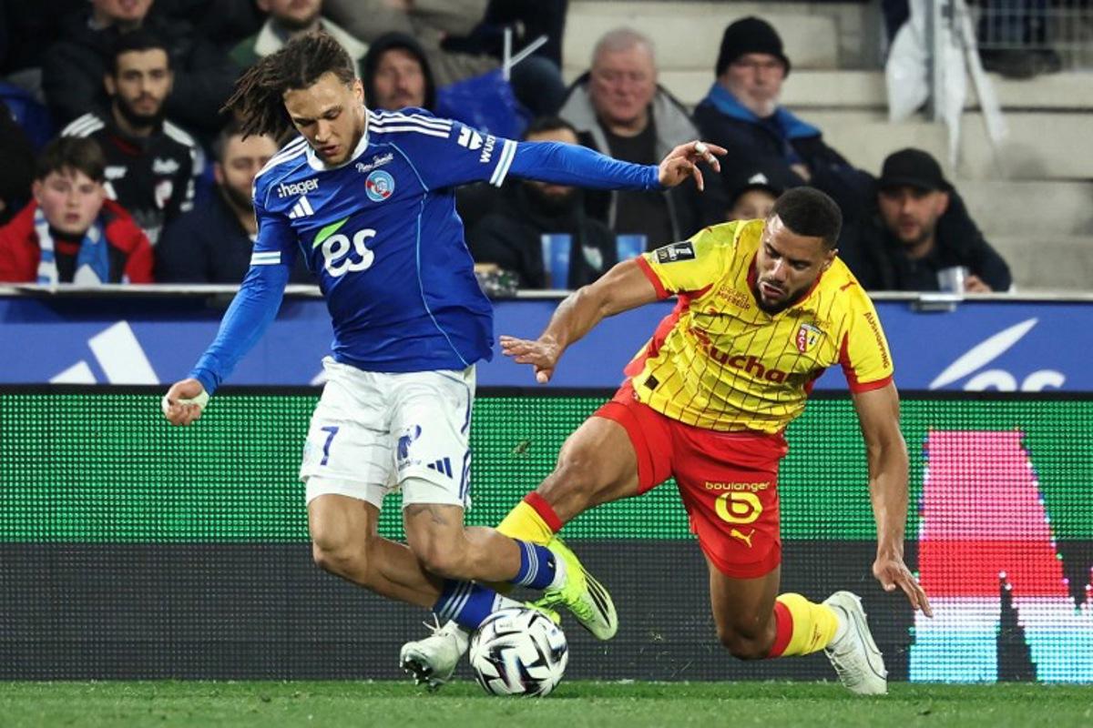Lens' French defender #14 Matthieu Udol (R) fights for the ball with Strasbourg's Belgian midfielder #07 Diego Moreira during the French L1 football match between RC Strasbourg Alsace and Lens (RCL) at the Stade de la Meinau in Strasbourg, eastern France, on February 27, 2026. Frederick FLORIN / AFP