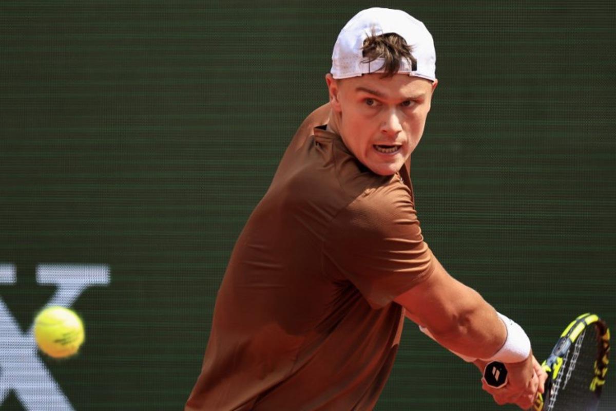 Denmark's Holger Rune plays a backhand return to Portugal's Nuno Borges during the Monte Carlo ATP Masters Series Tournament round of 64 tennis match on the Rainier III court at the Monte Carlo Country Club in Roquebrune-Cap-Martin on April 8, 2025. Valery HACHE / AFP