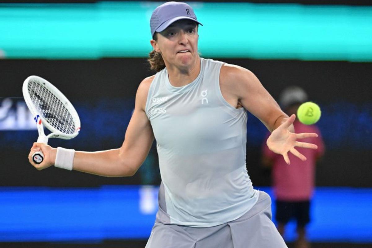 Poland's Iga Swiatek hits a return to Italy's Jasmine Paolini during their women's singles quarter-final match at the Wuhan Open tennis tournament in Wuhan, central China's Hubei province on October 10, 2025. ADEK BERRY / AFP