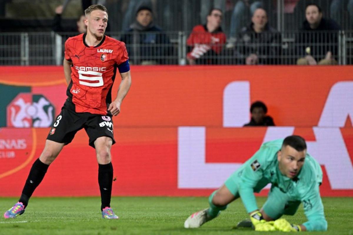 Rennes' French defender #03 Adrien Truffert (L) scores his team's first goal during the French L1 football match between Stade Rennais FC and FC Nantes at Roazhon Park stadium in Rennes, western France on April 18, 2025. DAMIEN MEYER / AFP