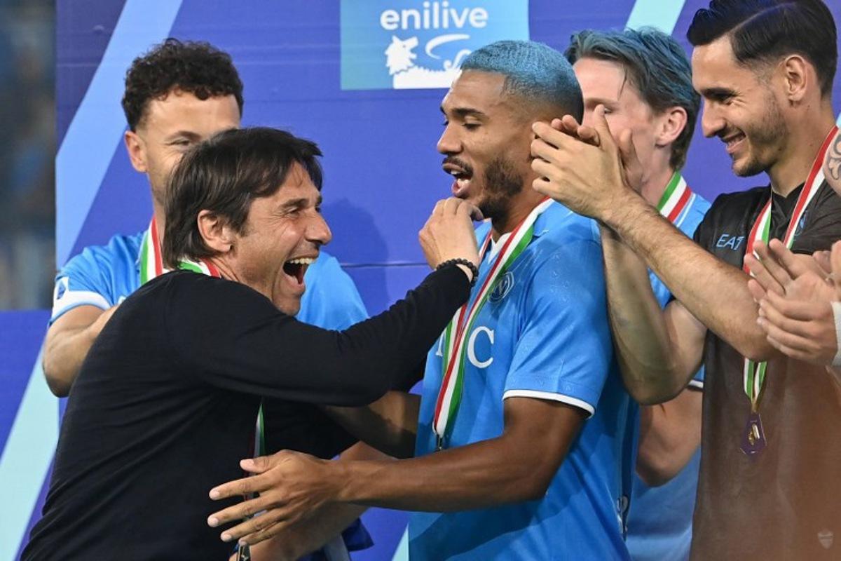 Napoli's Italian coach Antonio Conte (L) celebrates with Napoli's Brazilian defender #05 Juan Jesus during the trophy ceremony for the Italian Champions following the Italian Serie A football match between Napoli and Cagliari at the Diego Armando Maradona stadium in Naples on May 23, 2025. Isabella BONOTTO / AFP