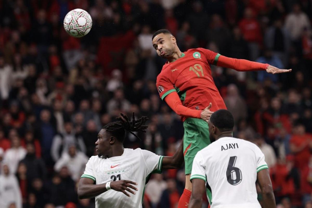 Morocco's forward #19 Youssef En-Nesyri jumps to head the ball next to Nigeria's defender #21 Calvin Bassey during the Africa Cup of Nations (CAN) semi-final football match between Nigeria and Morocco at the Prince Moulay Abdellah stadium in Rabat on January 14, 2026. FRANCK FIFE / AFP