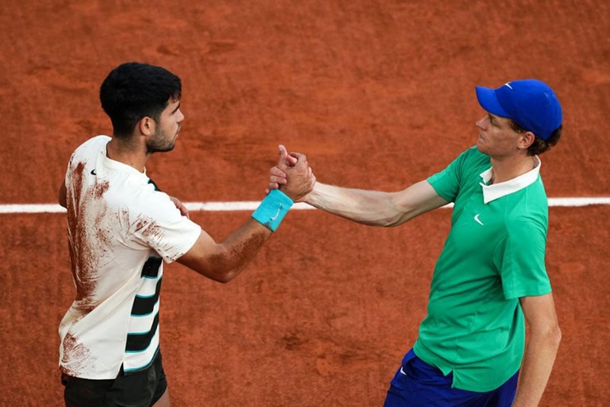Spain's Carlos Alcaraz (L) shakes hands with Italy's Jannik Sinner after winning the men's singles final match on day 15 of the French Open tennis tournament on Court Philippe-Chatrier at the Roland-Garros Complex in Paris on June 8, 2025. Dimitar DILKOFF / AFP