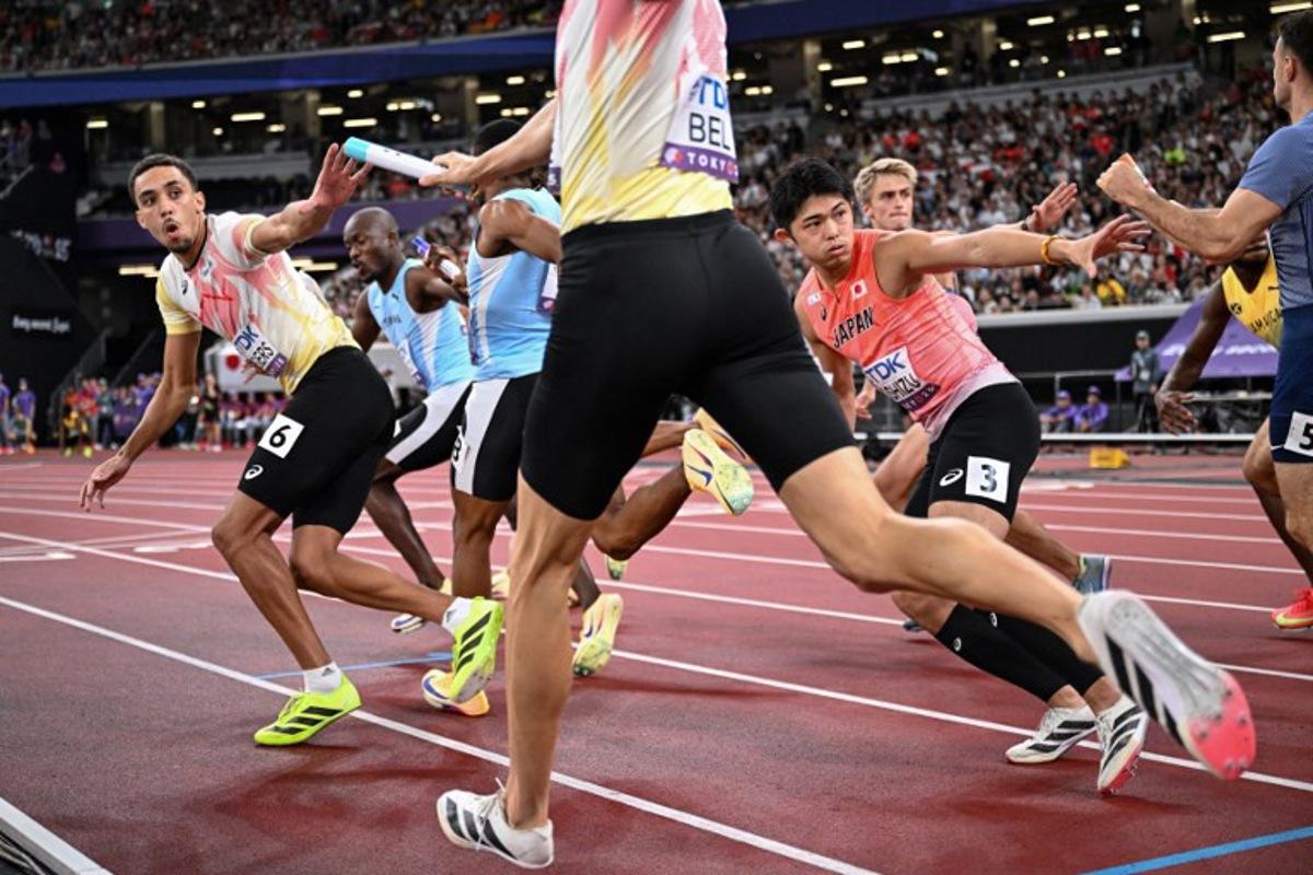 Athletes including Belgium's athlete Daniel Segers (L) receive the baton as they compete in the men's 4x400m relay heat 2 during the World Athletics Championships in Tokyo on September 20, 2025. Kirill KUDRYAVTSEV / AFP