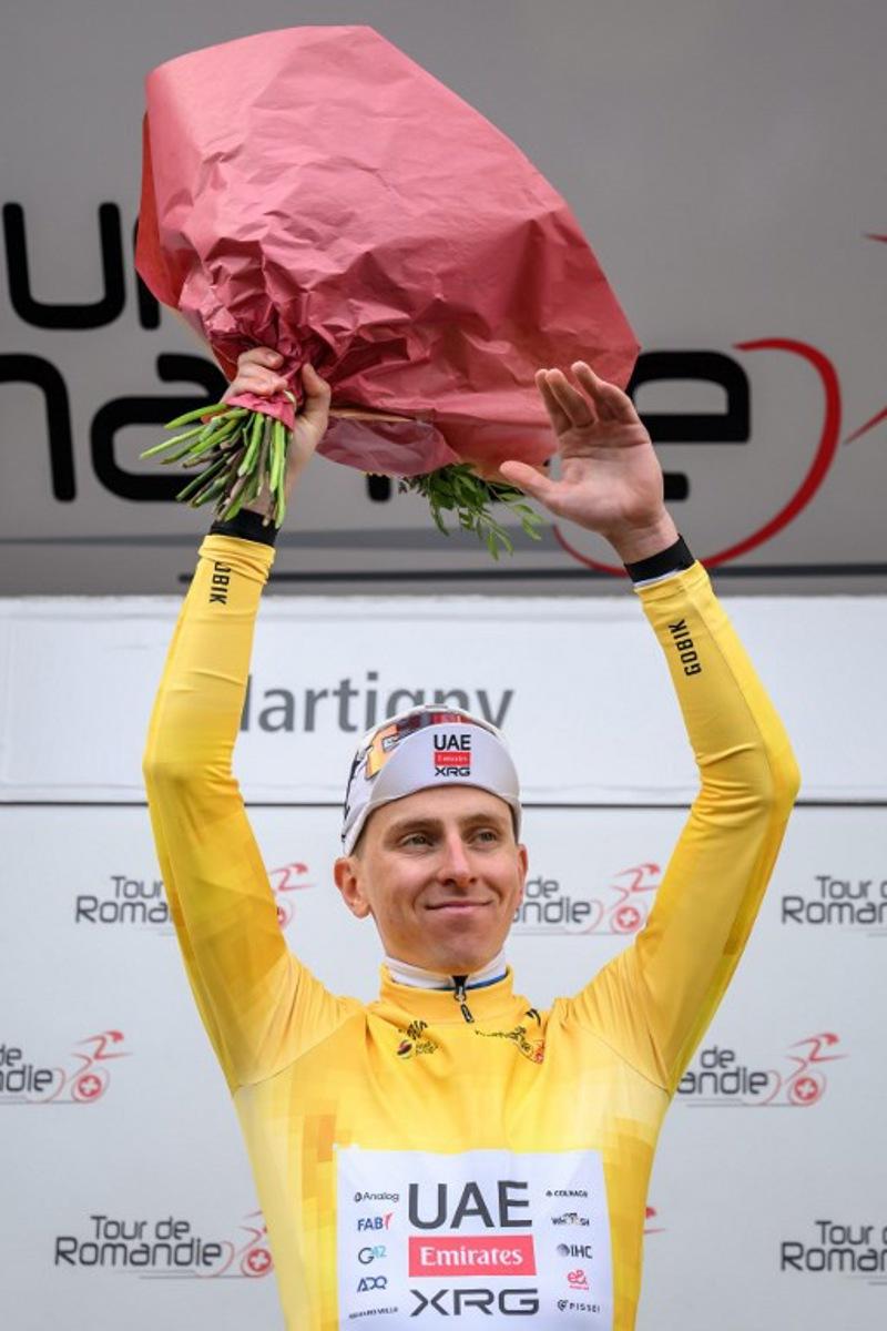 UAE Team Emirates-XRG's Slovenian rider Tadej Pogacar wearing the overall leader's yellow jersey celebrates on the podium of the first stage of the Tour of Romandie UCI cycling World tour, a 171.2 km loop from Martigny-Ville to Martigny-Ville, in Martigny, on April 29, 2026. Fabrice COFFRINI / AFP