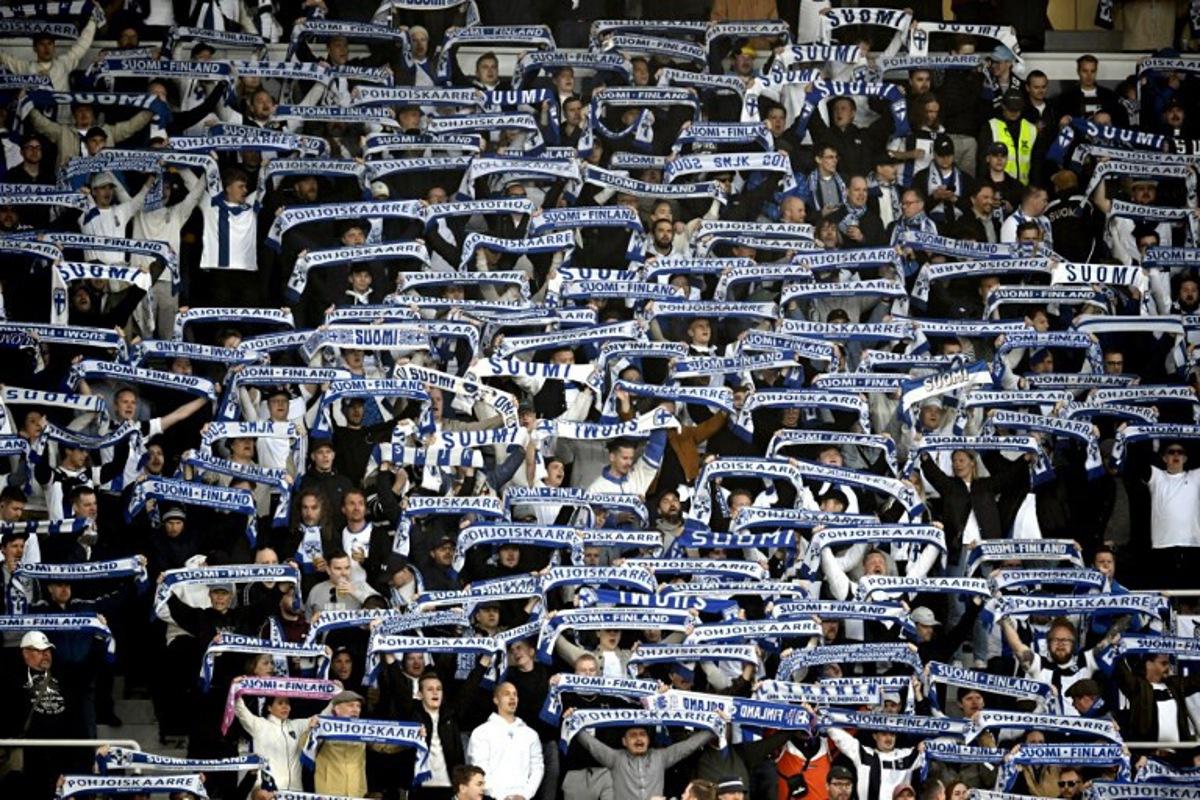 Finland fans display their scarves prior to the 2026 FIFA World Cup Qualifying Group G football match between Finland and Poland in Helsinki on June 10, 2025. Markku Ulander / LEHTIKUVA / AFP