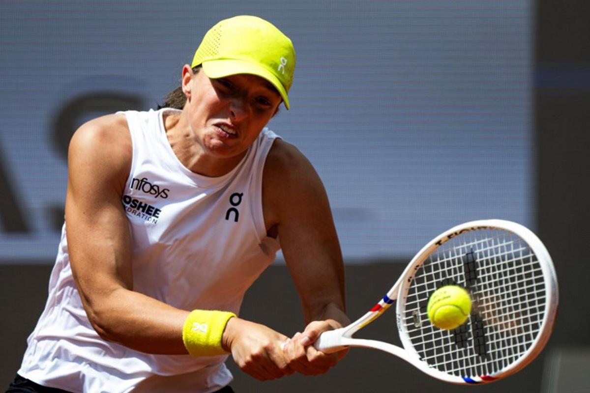 Poland's Iga Swiatek plays a backhand return to US' Danielle Collins during their women's singles match of the WTA Rome Open tennis tournament at Foro Italico in Rome on May 10, 2025. MARCO BERTORELLO / AFP