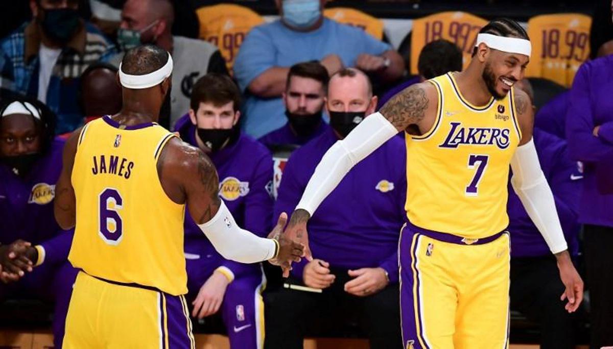 LeBron James and Carmelo Anthony of the Los Angeles Lakers touch hands in a break of action against the Golden State Warriors during their NBA season opener in Los Angeles, California on October 19, 2021. Frederic J. BROWN / AFP
