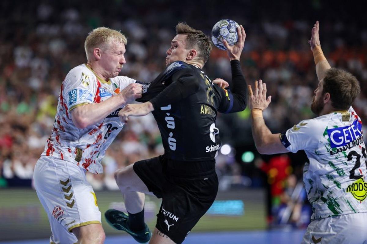 Fuechse Berlin's Danish left back #11 Lasse Bredekjaer Andersson (C) vies with Magdeburg's Danish line player #23 Magnus Saugstrup (L) and Magdeburg's Swedish right back #21 Albin Lagergren during the EHF Handball Champions League Final 4 gold medal match between Fuechse Berlin and SC Magdeburg in Cologne, western Germany on June 15, 2025. Ronny HARTMANN / afp