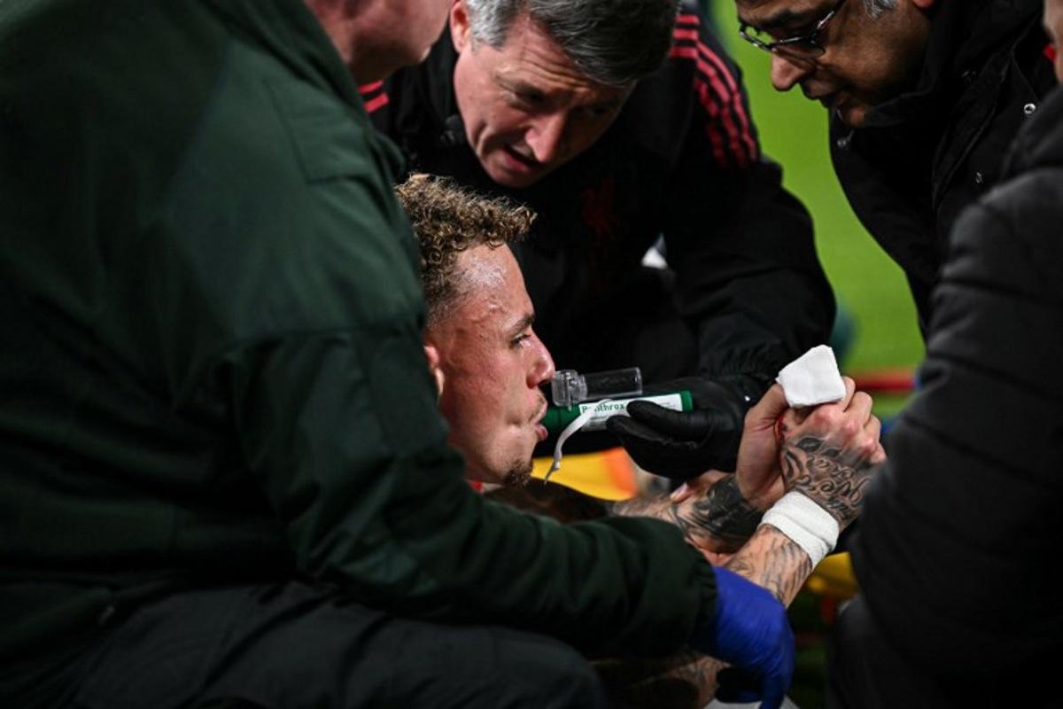 Galatasaray's Dutch forward #77 Noa Lang receives medical attention after cutting his thumb during the UEFA Champions League, round of 16 second leg football match between Liverpool and Galatasaray at Anfield in Liverpool, north-west England on March 18, 2026. Paul ELLIS / AFP