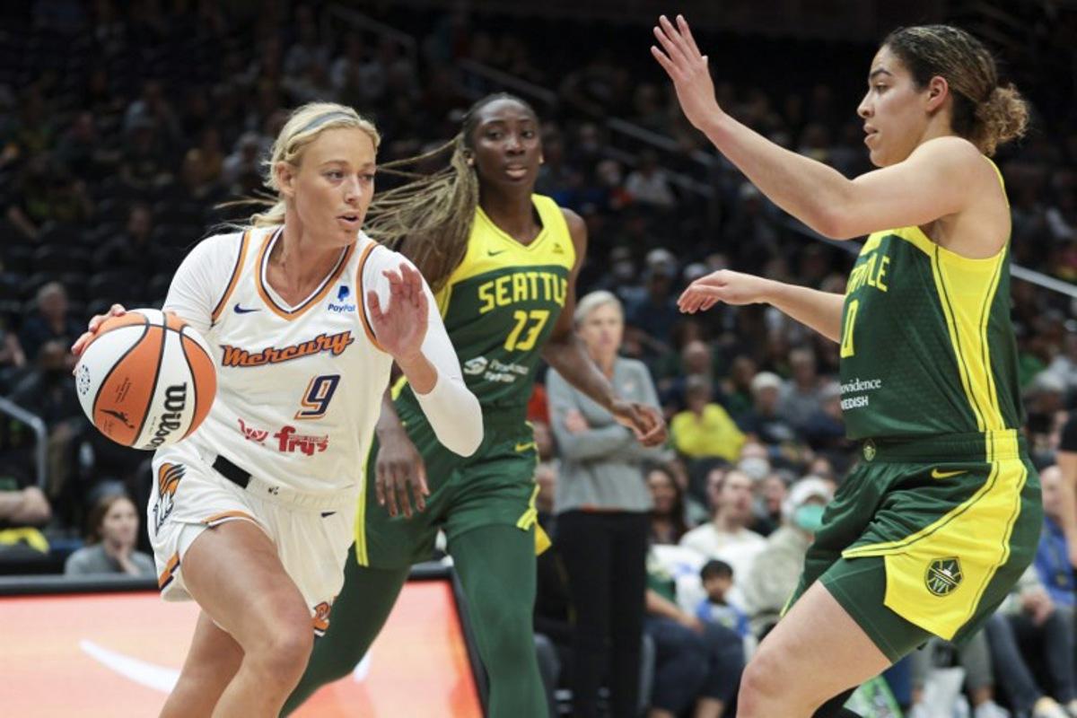 Phoenix Mercury guard Sophie Cunningham (L) drives to the basket as Seattle Storm center Ezi Magbegor (2nd L) and guard Kia Nurse (R) defend during the WNBA preseason basketball game between Phoenix Mercury and Seattle Storm at Climate Pledge Arena in Seattle, Washington, on May 8, 2023. Jason Redmond / AFP