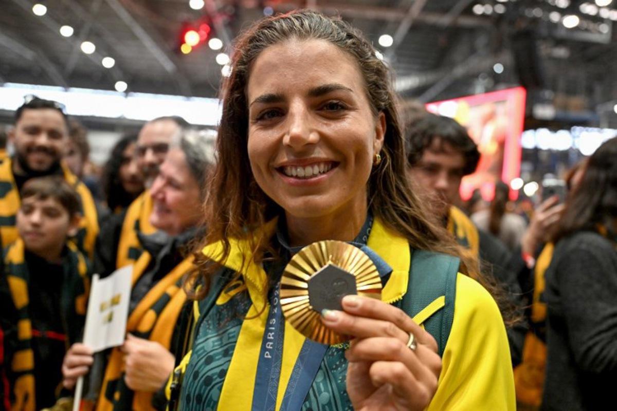 Australia's Jessica Fox, gold medallist in the women's canoe slalom kayak single and canoe single events, displays her medal during an event following her return from the Paris 2024 Olympic Games at the Sydney International Airport on August 14, 2024. Saeed KHAN / AFP