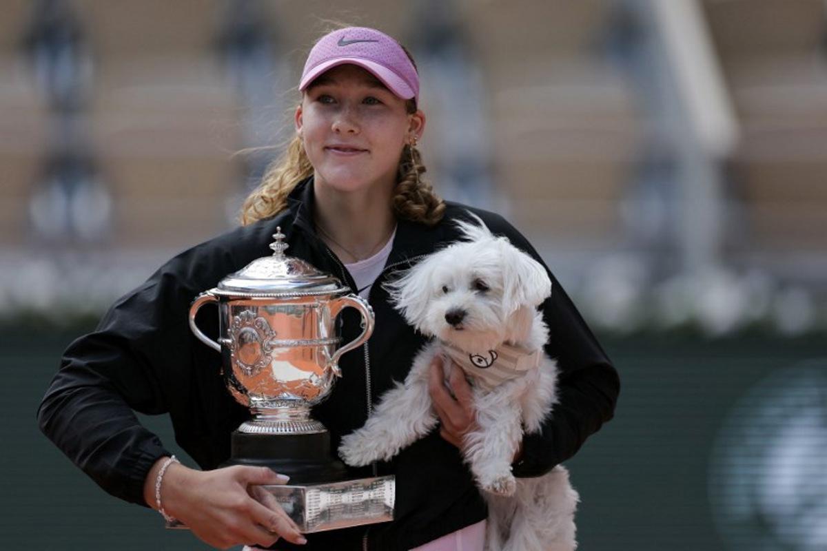 Russia's Mirra Andreeva poses with the Coupe Suzanne Lenglen (Suzanne Lenglen Trophy) and her dog after winning the French Open tennis tournament women's singles final match against Poland's Maja Chwalinska on day 14 of the French Open tennis tournament on Court Philippe-Chatrier at the Roland-Garros Complex in Paris on June 6, 2026. Thomas SAMSON / AFP