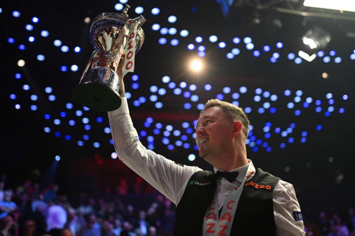 England's Kyren Wilson celebrates with the trophy after victory over Wales' Jak Jones on day two of their World Championship Snooker final at The Crucible in Sheffield, northern England on May 6, 2024. Wilson won the final 18-14. Oli SCARFF / AFP
