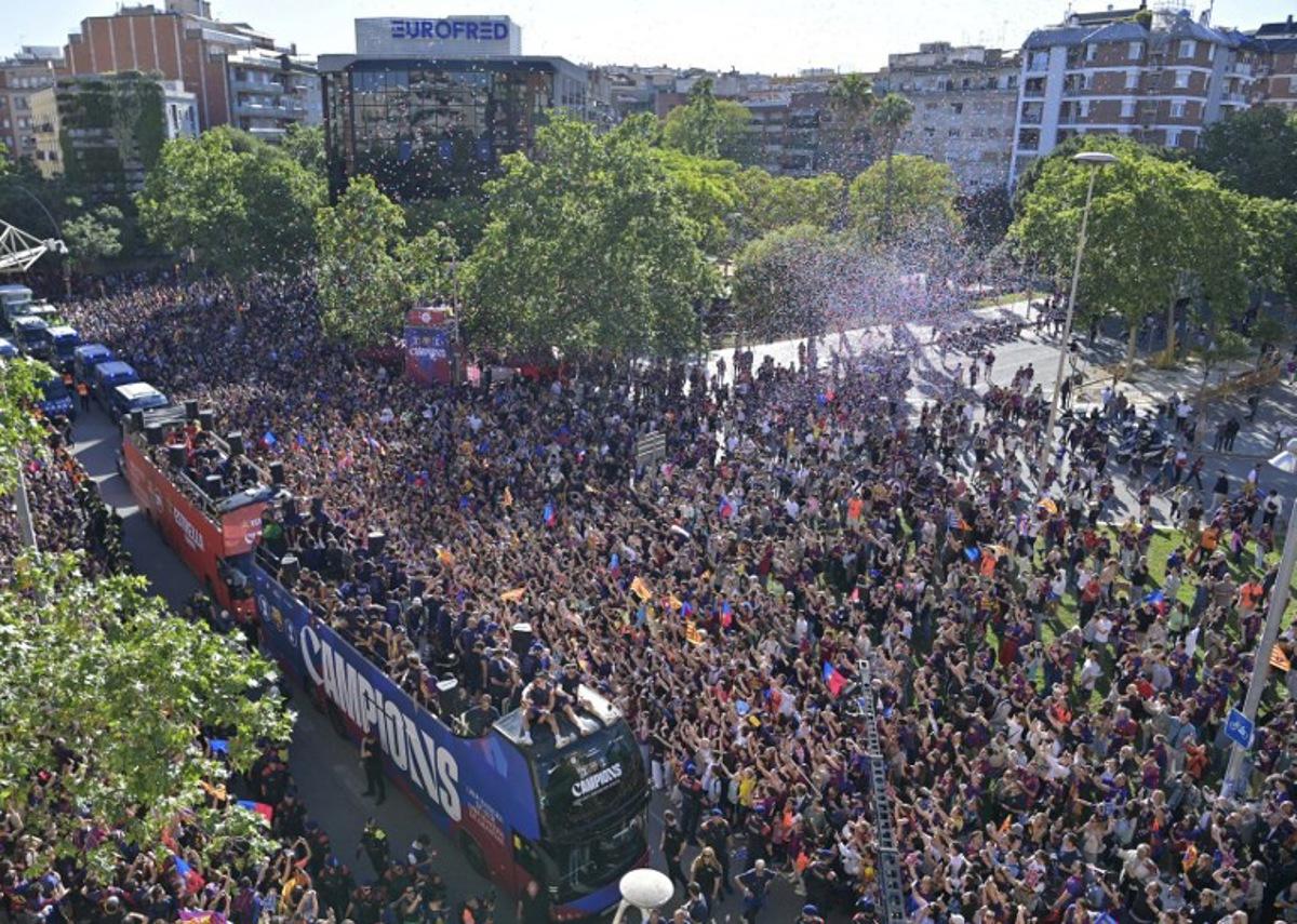 Supporters gather as Barcelona's players celebrate aboard a bus winning their 29th Spanish league title in Barcelona on May 11, 2026. Barcelona secured their 29th Spanish league title after beating Real Madrid 2-0 in the Clasico on May 10, 2026. MANAURE QUINTERO / AFP