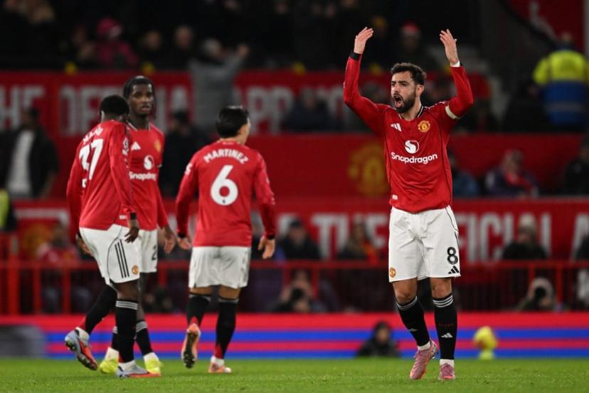 Manchester United's Portuguese midfielder #08 Bruno Fernandes gestures to the crowd as he celebrates scoring their third goal to equalise 3-3 during the English Premier League football match between Manchester United and Bournemouth at Old Trafford in Manchester, north west England, on December 15, 2025. PETER POWELL / AFP