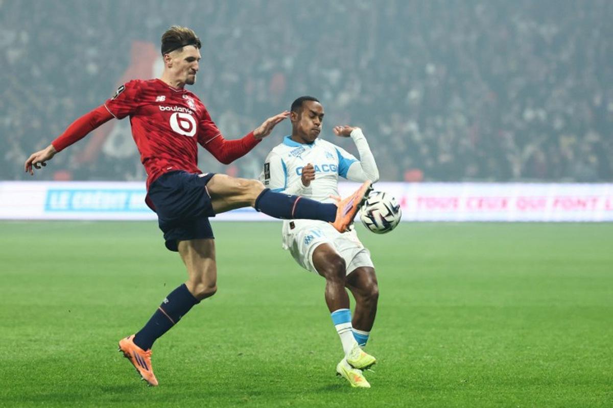 Lille's Belgian defender #12 Thomas Meunier (L) and Marseille's Brazilian forward #14 Igor Paixao fight for the ball during the French L1 football match between Lille LOSC and Olympique de Marseille (OM) at the Pierre-Mauroy stadium in Villeneuve-d'Ascq, northern France, on December 5, 2025. Sameer AL-DOUMY / AFP
